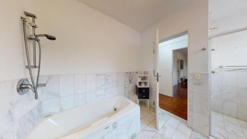 a white bathroom with a tub and a shower at Becas House in Sao Paulo