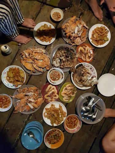 a table with many plates of food on it at Antonio's ko yao noi BED & Pool in Ko Yao Noi