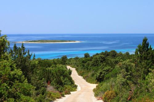 a dirt road leading to an island in the ocean at Apartments with parking space Savar, Dugi otok - 8127 in Savar