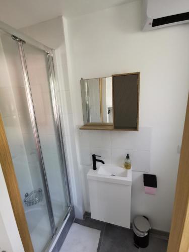 une salle de bain blanche avec un lavabo et une douche dans l'établissement Superbe appartement Montpellier 8 personnes 2 chambres 2 salles de bain Wifi Netflix et parking gratuit, à Montpellier