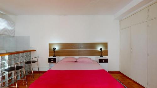 a bedroom with a bed with a red blanket at Becas House in Sao Paulo