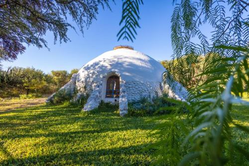 a dome house in the middle of a field at Posada Arco Iris in San Marcos Sierras