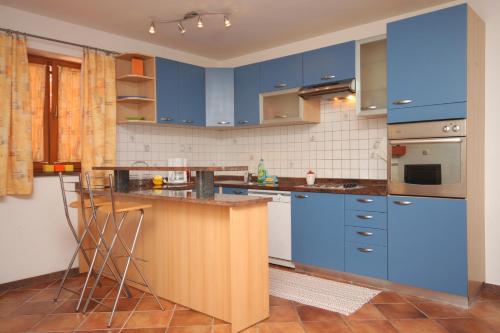 a kitchen with blue cabinets and a counter at Apartments with parking space Kraj, Opatija - 7794 in Kraj