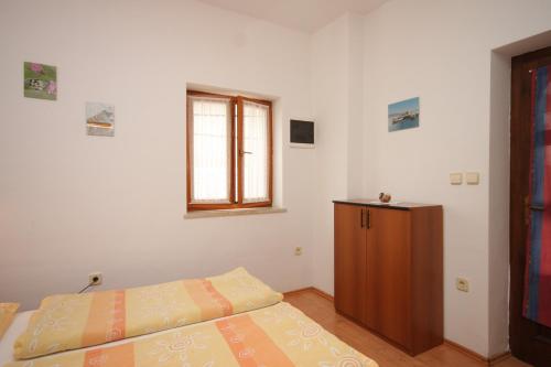 a bedroom with a bed and a wooden cabinet at Studio Kraj 7794b in Kraj