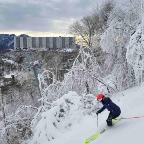 a person on skis in the snow near a ski lift at Altitude Adjustment atop Sugar Mountain at Sugar Top in Sugar Mountain