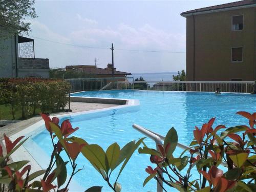 a large blue swimming pool next to a building at Villa Mimosa in Bardolino
