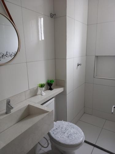 a white bathroom with a sink and a toilet at Apartamento, Zona Leste, ótima localização. in Teresina