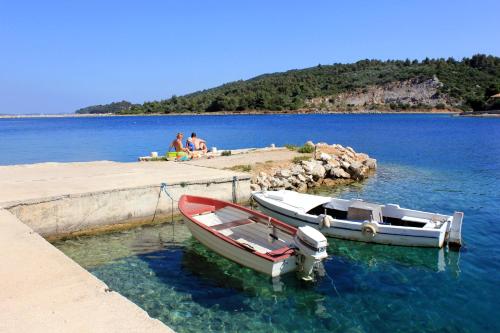 two boats are docked at a dock in the water at Apartments by the sea Zaglav, Dugi otok - 8134 in Sali