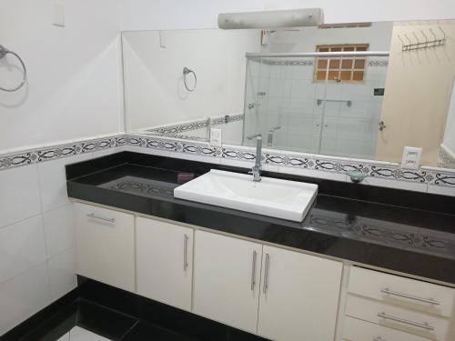 a white bathroom with a sink and a mirror at Spa Belo Quinto Prime in Brotas