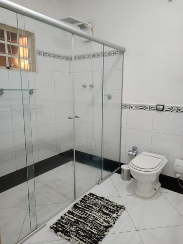 a bathroom with a shower with a toilet and a rug at Spa Belo Quinto Prime in Brotas