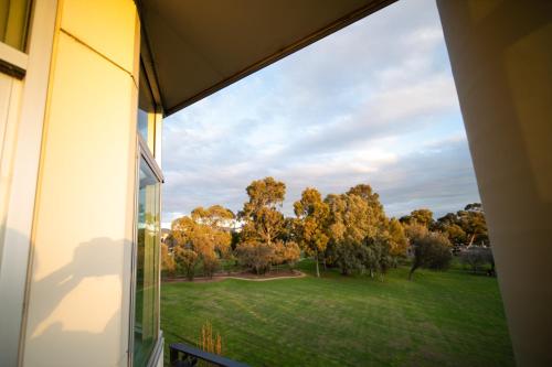 a window view of a park from a house at Sfera's Park Suites & Convention Centre in Adelaide