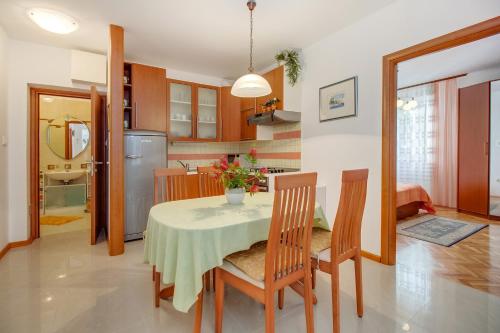 a kitchen and dining room with a table and chairs at Apartments with a parking space Mali Losinj (Losinj) - 8024 in Mali Lošinj