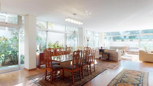 a living room with a glass table and chairs at Becas House in Sao Paulo