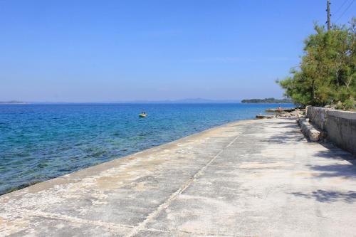 a pathway leading to the ocean with a boat in the water at Apartment Zman 887c in Žman