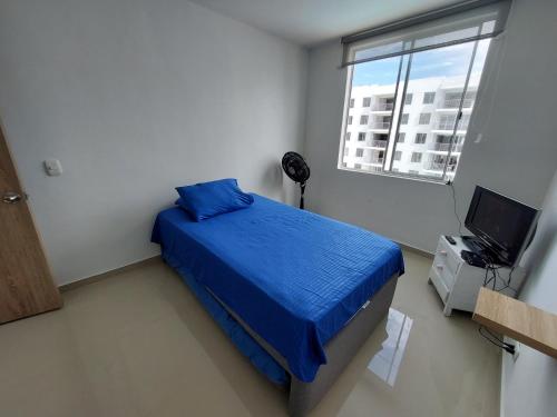 Un dormitorio con una cama azul y una ventana en Apartamento Aqualina Orange Piso Octavo Vista a Piscina, en Girardot