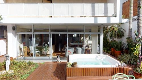 a house with a hot tub on a deck at Becas House in Sao Paulo