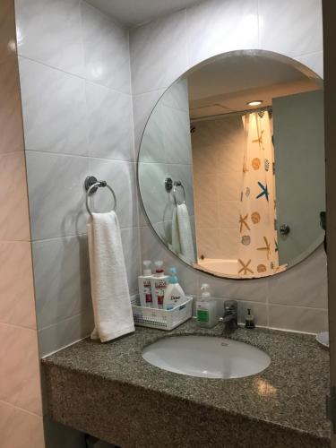 a bathroom with a sink and a mirror at Omnitower two bedroom cozy apartment in Bangkok