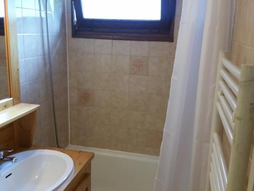a bathroom with a sink and a tub and a window at Appartement La Clusaz, 3 pièces, 6 personnes - FR-1-459-191 in La Clusaz