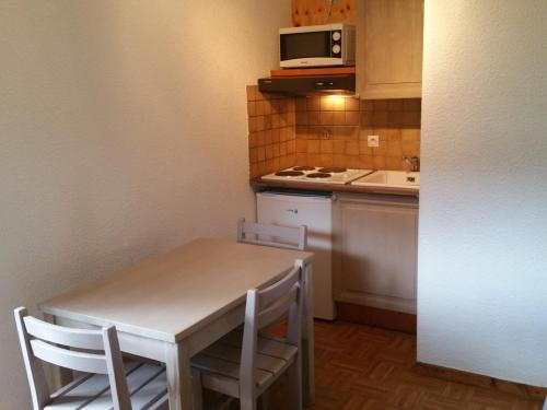 une petite cuisine avec une table et un micro-ondes dans l'établissement Charmant T2 avec balcon au cœur de La Clusaz, proche commerces et pistes - 4 pers. - FR-1-459-192, à La Clusaz