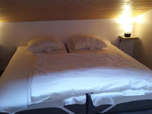 Elle comprend un grand lit avec des draps et des oreillers blancs. dans l'établissement Charmant T2 avec balcon au cœur de La Clusaz, proche commerces et pistes - 4 pers. - FR-1-459-192, à La Clusaz