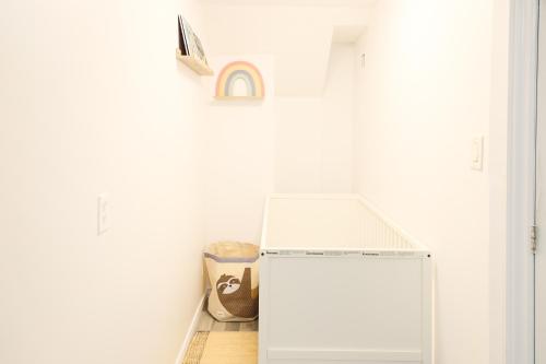 a small white refrigerator in a white room at Family-Friendly Boho Stay - Sleeps 10 - Near the Falls in Thorold
