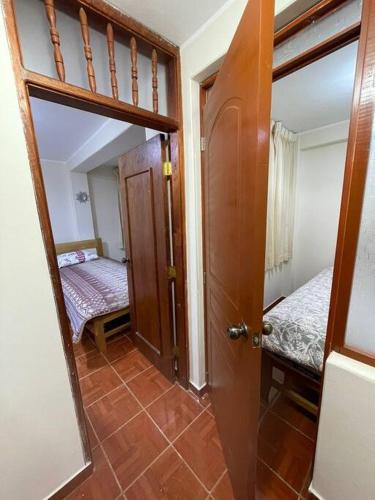Habitación con puerta y dormitorio con cama en Departamento D&C I entero acogedor, en Huancayo