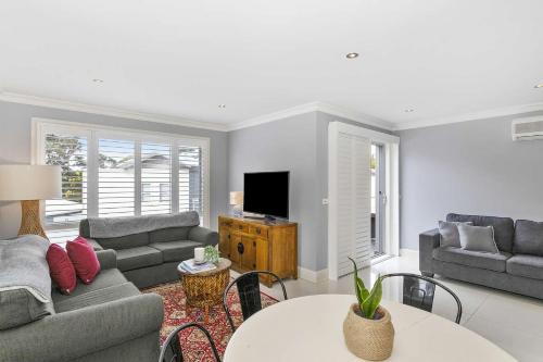 a living room with a couch and a table at North Harbour in Ulladulla