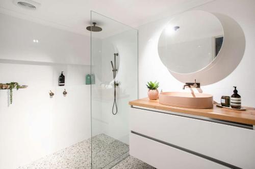 een badkamer met een wastafel en een spiegel bij Relax at The Sands in Mollymook