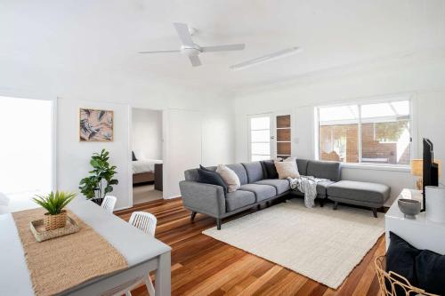 a living room with a couch and a table at Barefoot Bungalow in Mollymook
