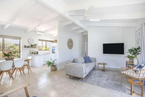 a living room with a couch and a tv at Birdsea House in Narrawallee