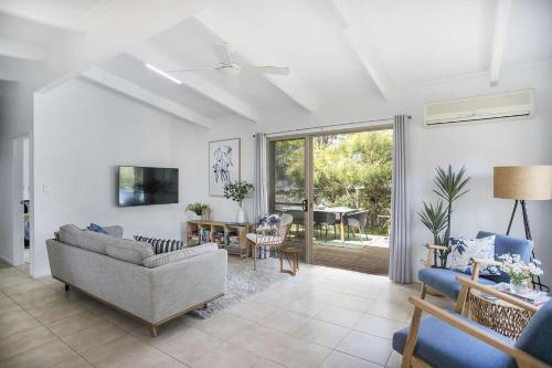 a living room with a couch and a table at Birdsea House in Narrawallee