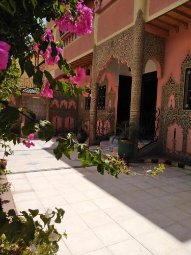 un cortile di un edificio con fiori rosa di Villa Eden a Ouarzazate