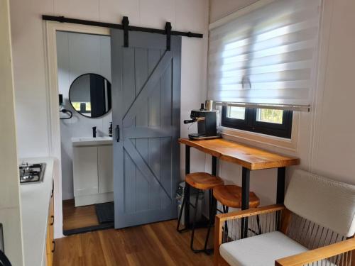 a door leading into a kitchen with a table and a desk at Tiny Homes in Hartley