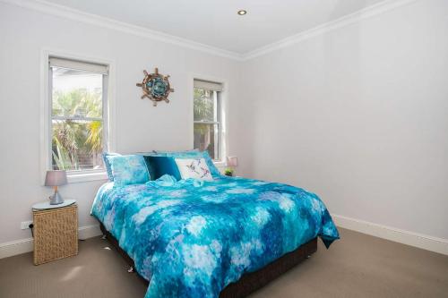 a bedroom with a blue comforter on a bed at Harbour Haven in Ulladulla