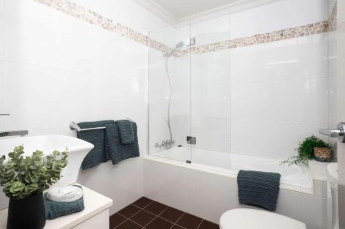 uma casa de banho branca com um WC e um chuveiro em Harbour Haven em Ulladulla