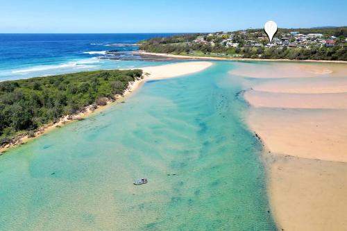 an aerial view of a beach with a boat in the water at SurfBreak on Seaside in Burrill Lake