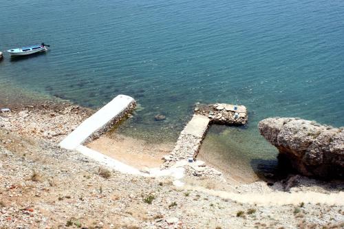 a body of water with a boat in the water at Apartments by the sea Zubovici, Pag - 9678 in Zubovići