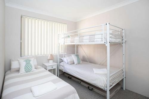 Un dormitorio con dos literas y una ventana. en Surfmist One on Mollymook, en Mollymook