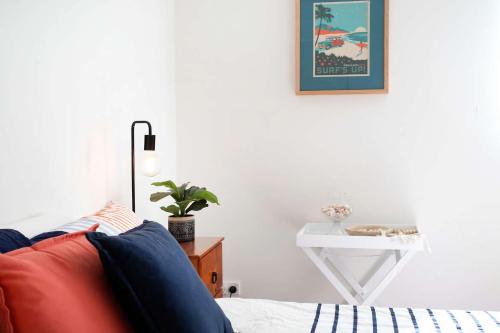 a bedroom with a red couch and a white table at Beachfront Four in Mollymook