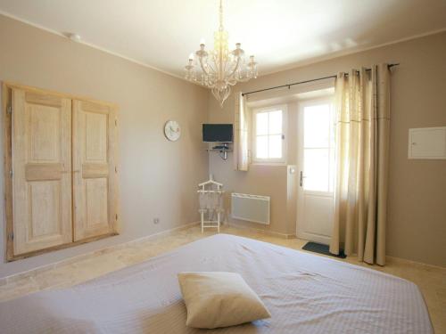 a bedroom with a large white bed with a chandelier at Villa in Provence with Infinity Pool in Martres-Tolosane