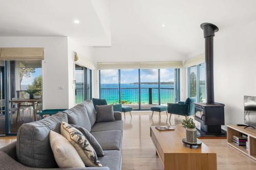 a living room with a couch and a fireplace at Northstar on Mollymook Beach in Mollymook