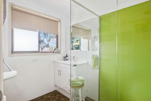 a bathroom with a glass shower and a sink at Narrawallee Retreat in Narrawallee
