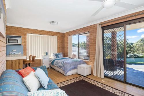 a living room with a bed and a window at Narrawallee Retreat in Narrawallee