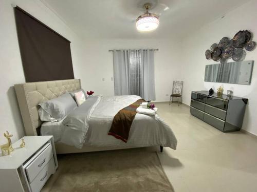 een slaapkamer met een bed, een dressoir en een wastafel bij hacienda in Santiago de los Caballeros