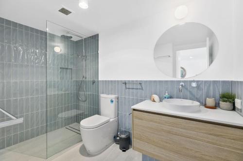 Un baño con inodoro, lavabo y ducha. en Unit 5 Vista Pacific 12 14 Bryan Street Sunshine Beach, en Sunshine Beach