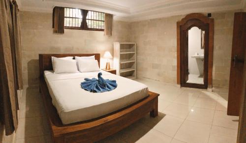 a bedroom with a bed with a blue towel on it at Darma Yogi House in Ubud