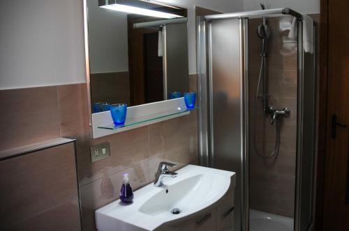 a bathroom with a sink and a shower with a mirror at B&B Luna di Langa in Alba