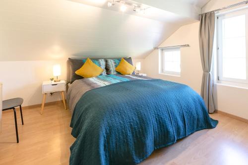 a bedroom with a large bed with a blue blanket at Spirit Apartments - Balkon mit Seesicht - Parkplatz in Brienz