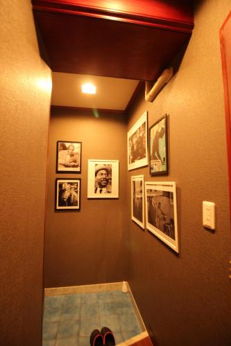 Hotel OLDSWING Adult Only في طوكيو: ممر به صور على الحائط وأحذية على الأرض