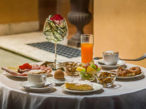 a table with breakfast foods and a glass of orange juice at Palazzo Cardinal Cesi in Rome